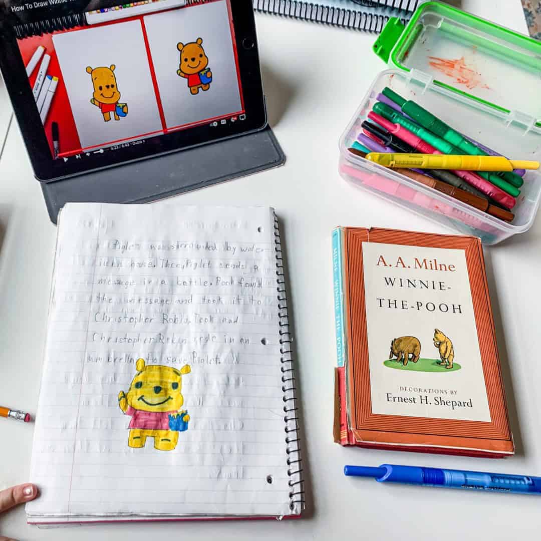 NEW (Mostly) Workbook Free Language Arts Method A colorful children's book and drawing supplies on a white desk, educational and creative scene.
